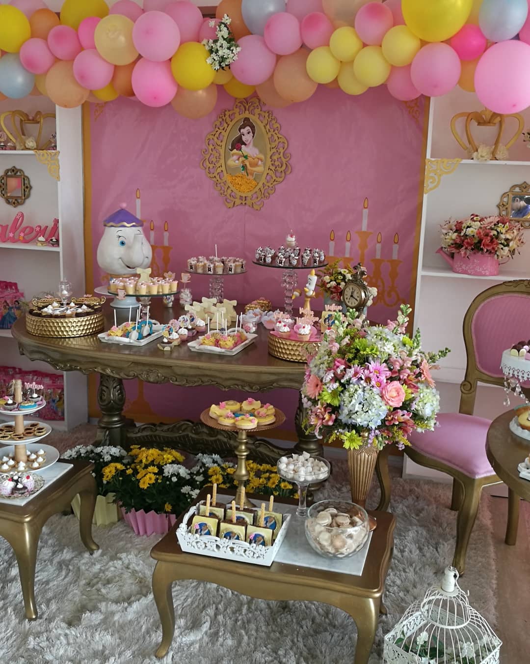 mesa de dulces decorada con globos de bella y la bestia