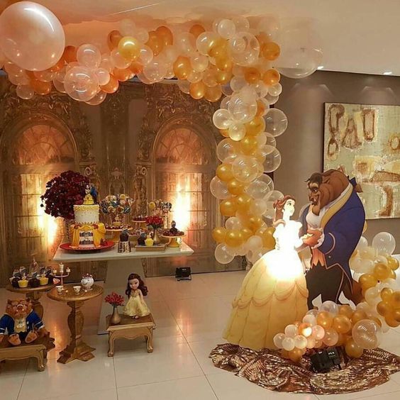 mesa de dulces decorada con globos de bella y la bestia