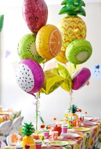 Centros de mesa con globos de piñas flamingos y frutas