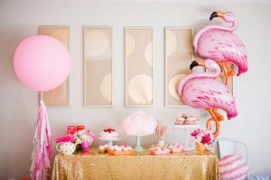 Mesas de postres con globos de piñas flamingos y frutas