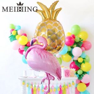 Mesas de postres con globos de piñas flamingos y frutas